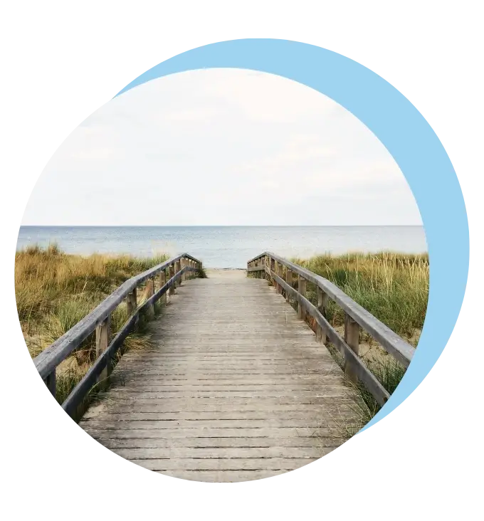 Drewniany mostek, prowadzący nad morze. Zdjęcie wpisane w koło